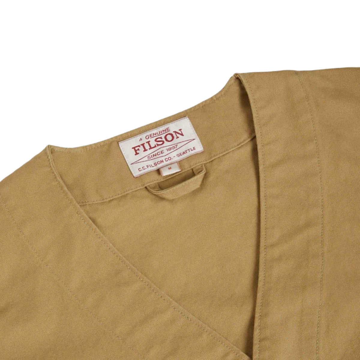 Close-up of a tan fabric with a Filson label on a white background