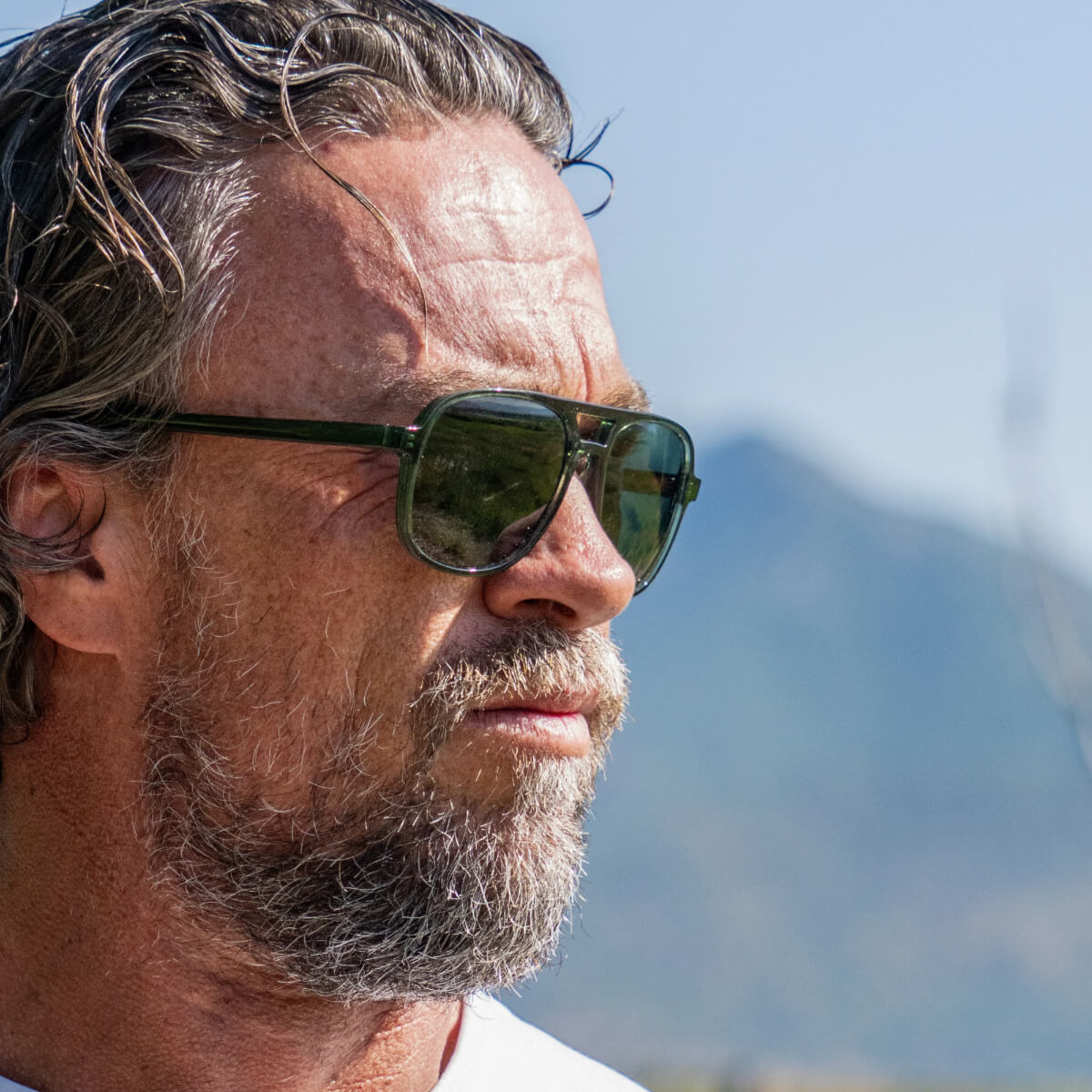 Man wearing Vallon sunglasses with mountains in the background