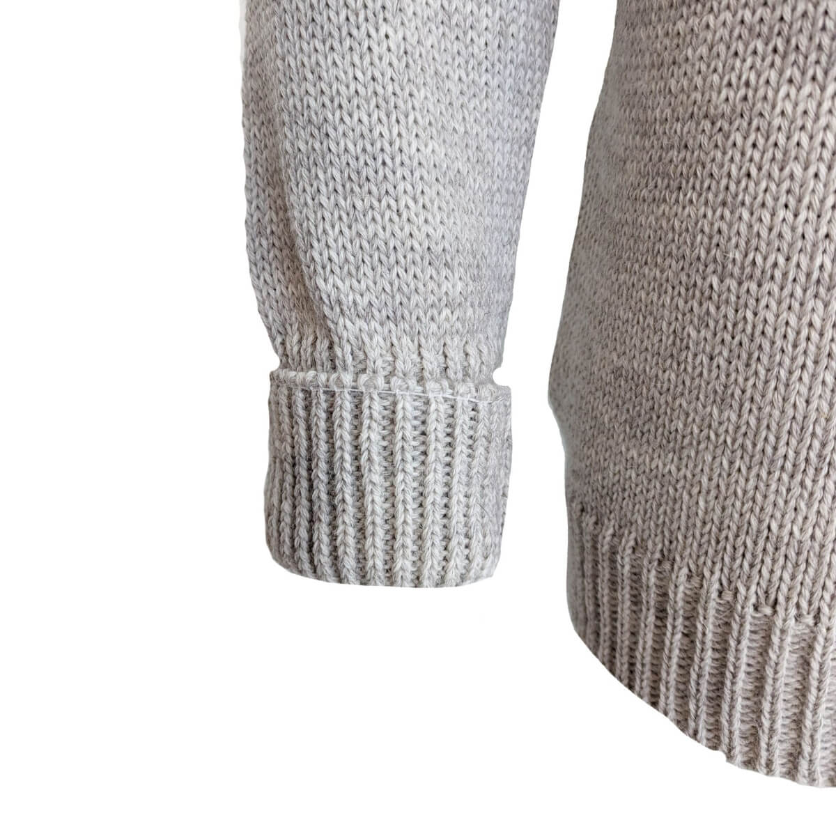 Close-up of a gray knitted sweater sleeve on a white background