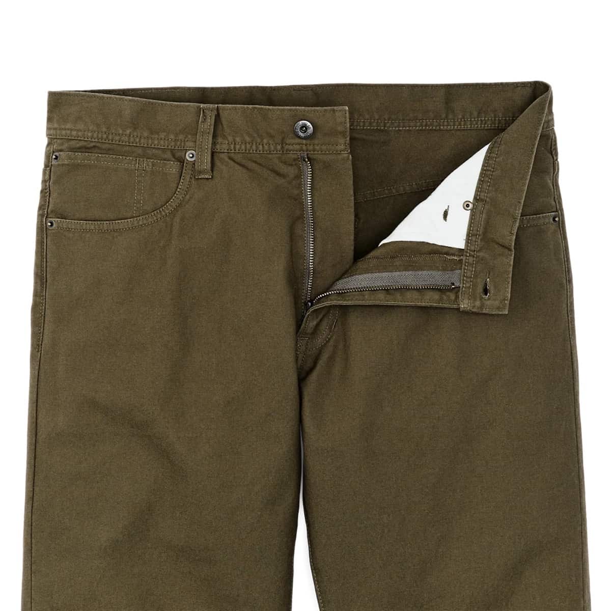 Close-up of olive green Filson pants showing the waistband, belt loops, front pockets, and a zipper pocket with the flap open to reveal a white lining.
