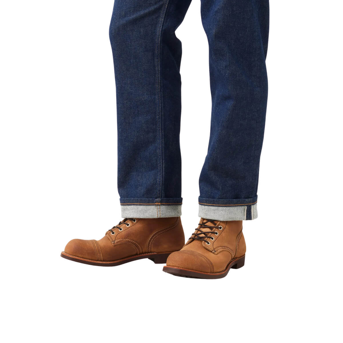 Brown leather boots and blue jeans on a white background