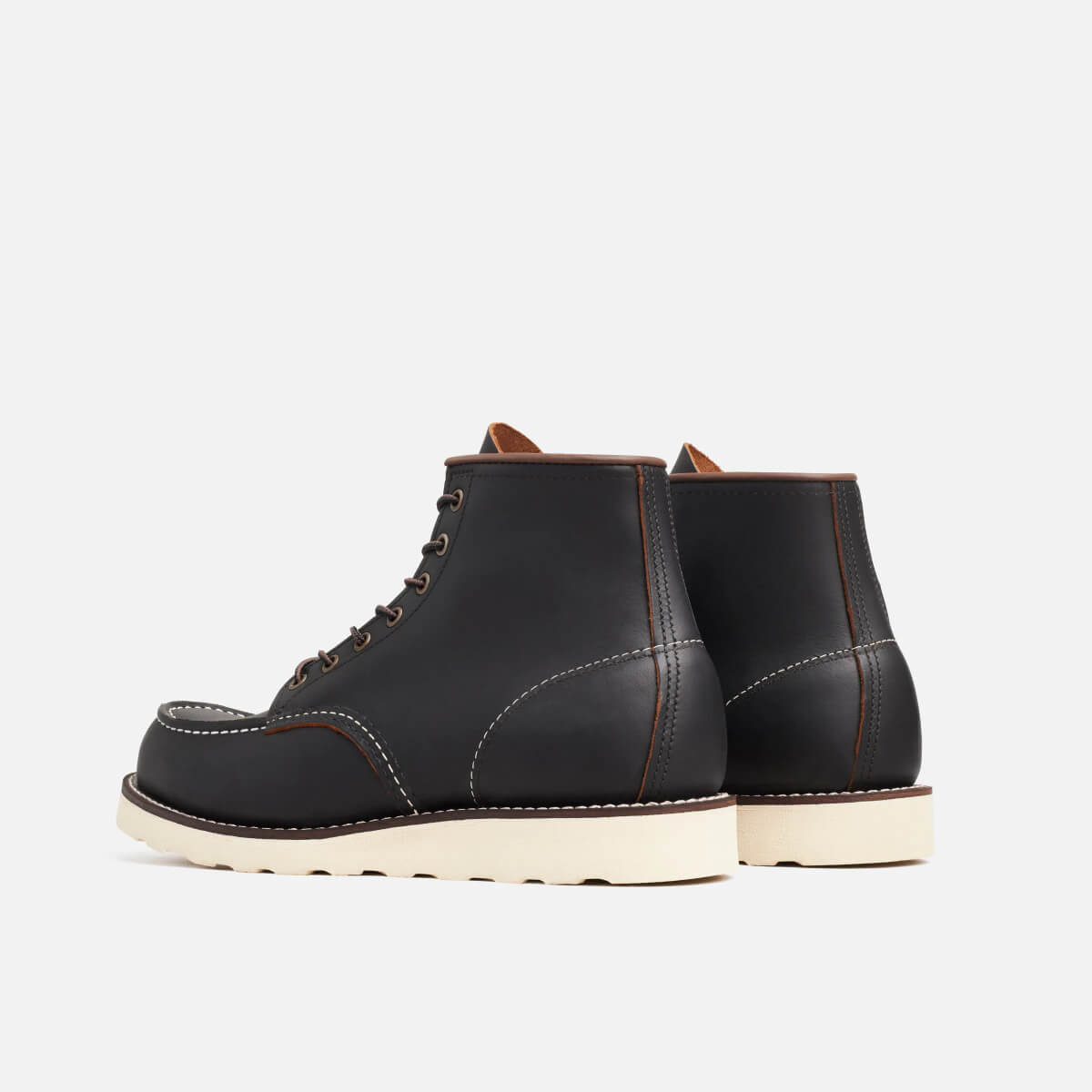 Pair of black leather boots on a light gray background