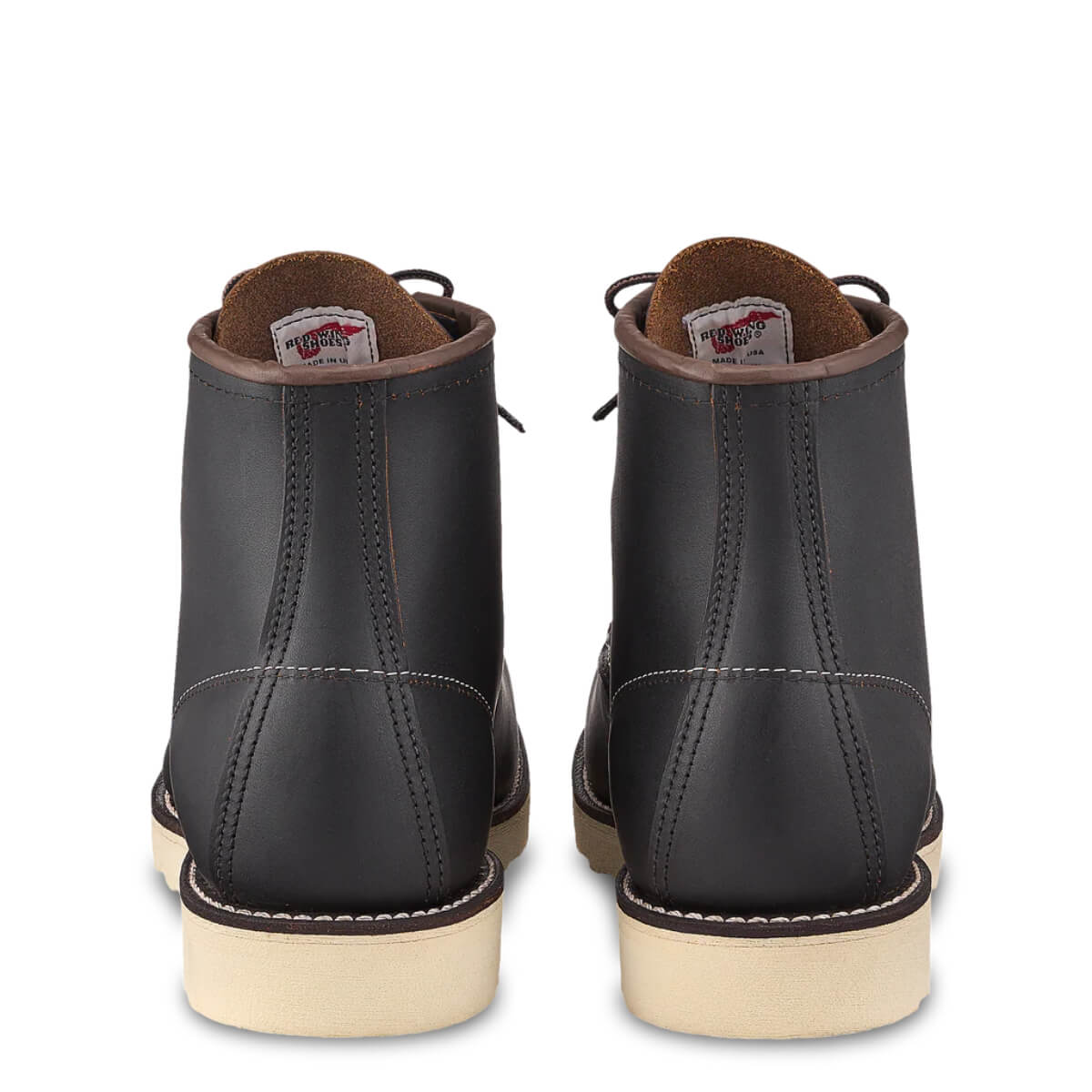 Black leather boots with tan soles on a white background