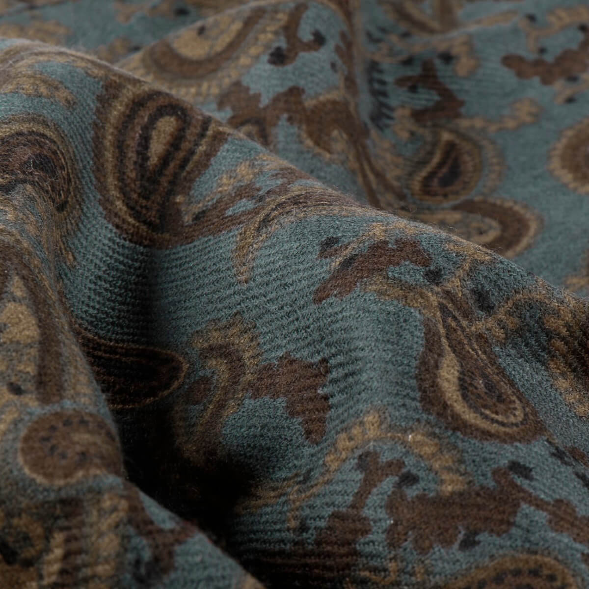 Close-up of textured fabric with a paisley pattern in brown and blue.