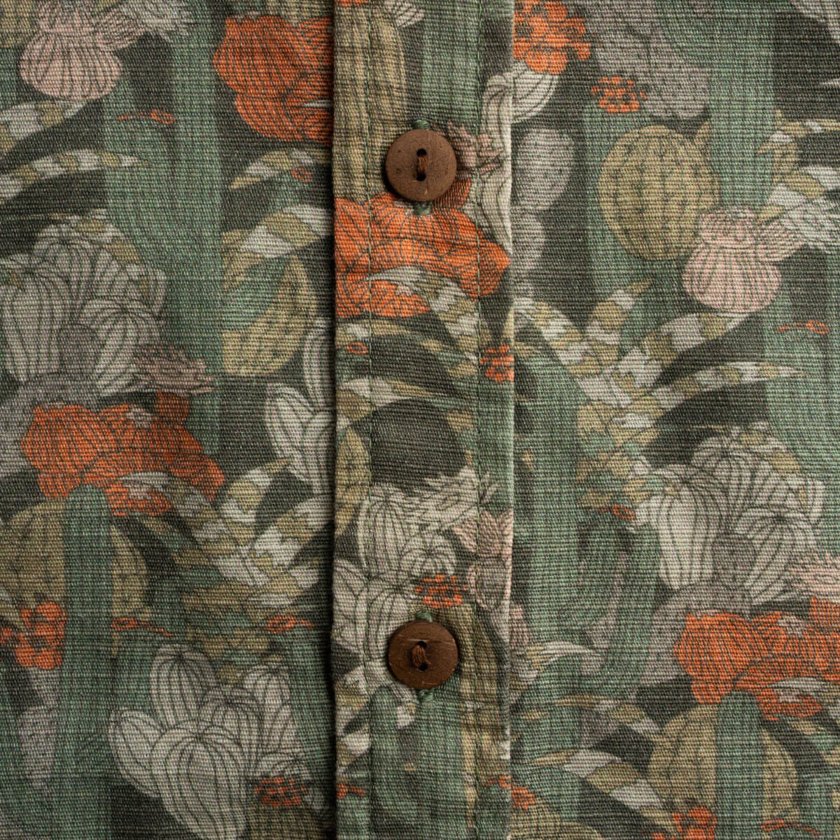 Floral patterned fabric with orange and green colors on a wooden surface.