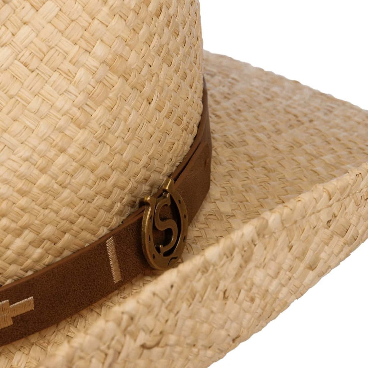 Close-up of a straw cowboy hat with a brown band featuring a logo.