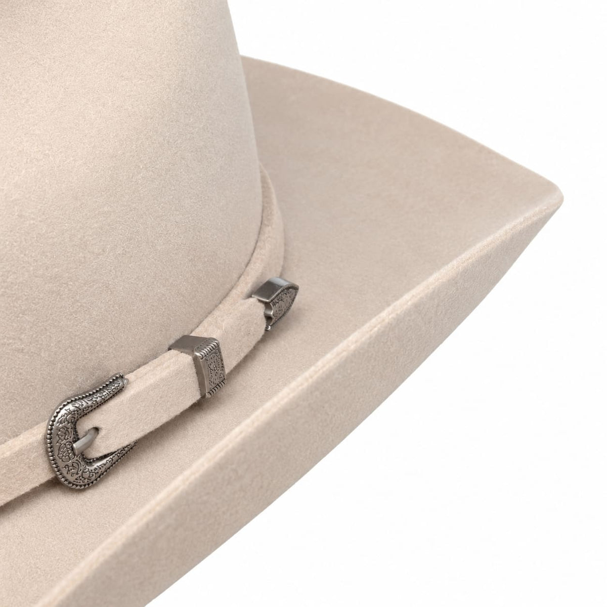 Close-up of a light beige Stetson felt cowboy hat with a matching hatband and a silver-toned buckle, shown on a white background.