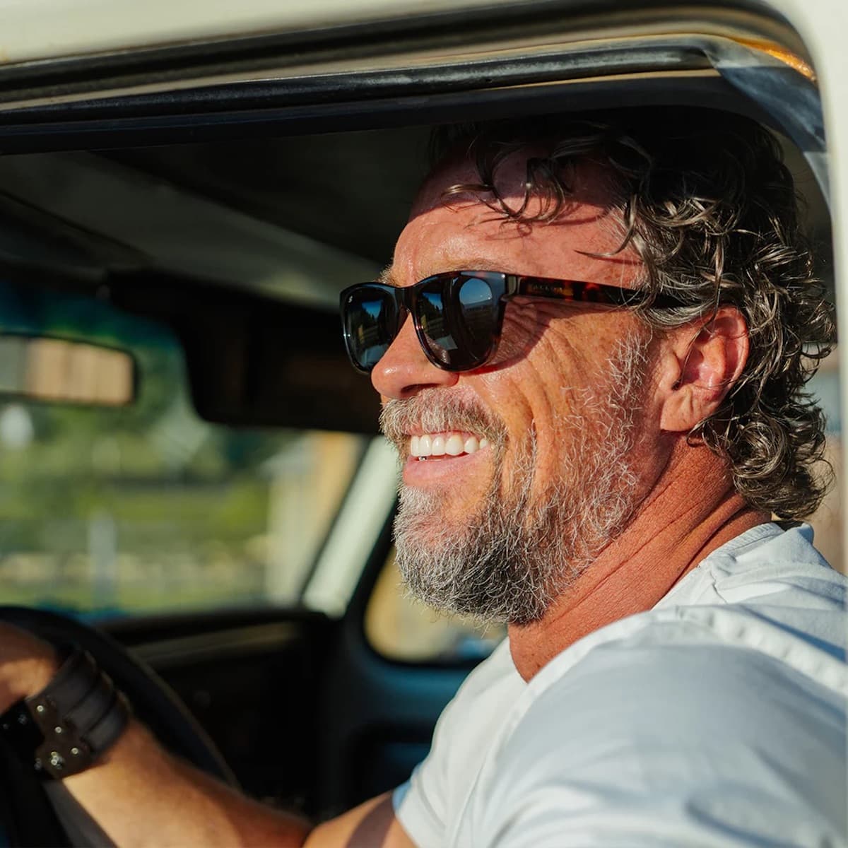 Man with Vallon sunglasses and a beard sitting inside a vehicle