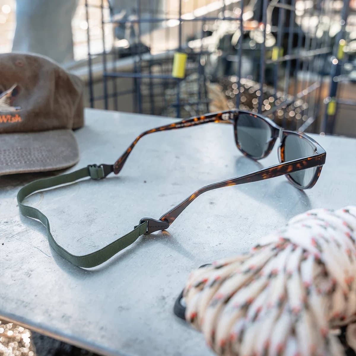 Vallon Sunglasses with a green strap on a table outdoors