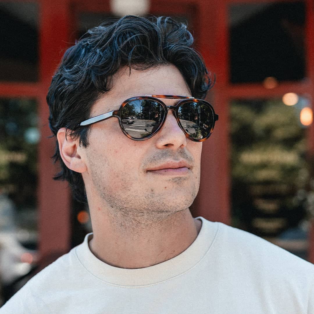 Man wearing Vallon Brow Bar Aviator Sunglasses with a blurred background