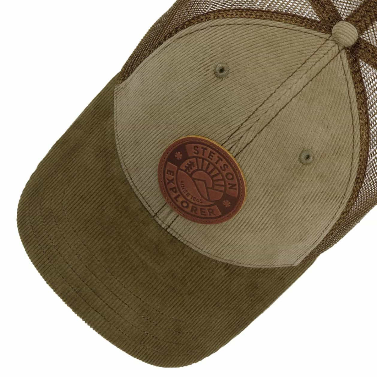 A close-up of a trucker-style cap with a brown corduroy visor, tan front panel, and brown mesh back. A circular brown leather patch on the front reads 'STETSON EXPLORER'.
