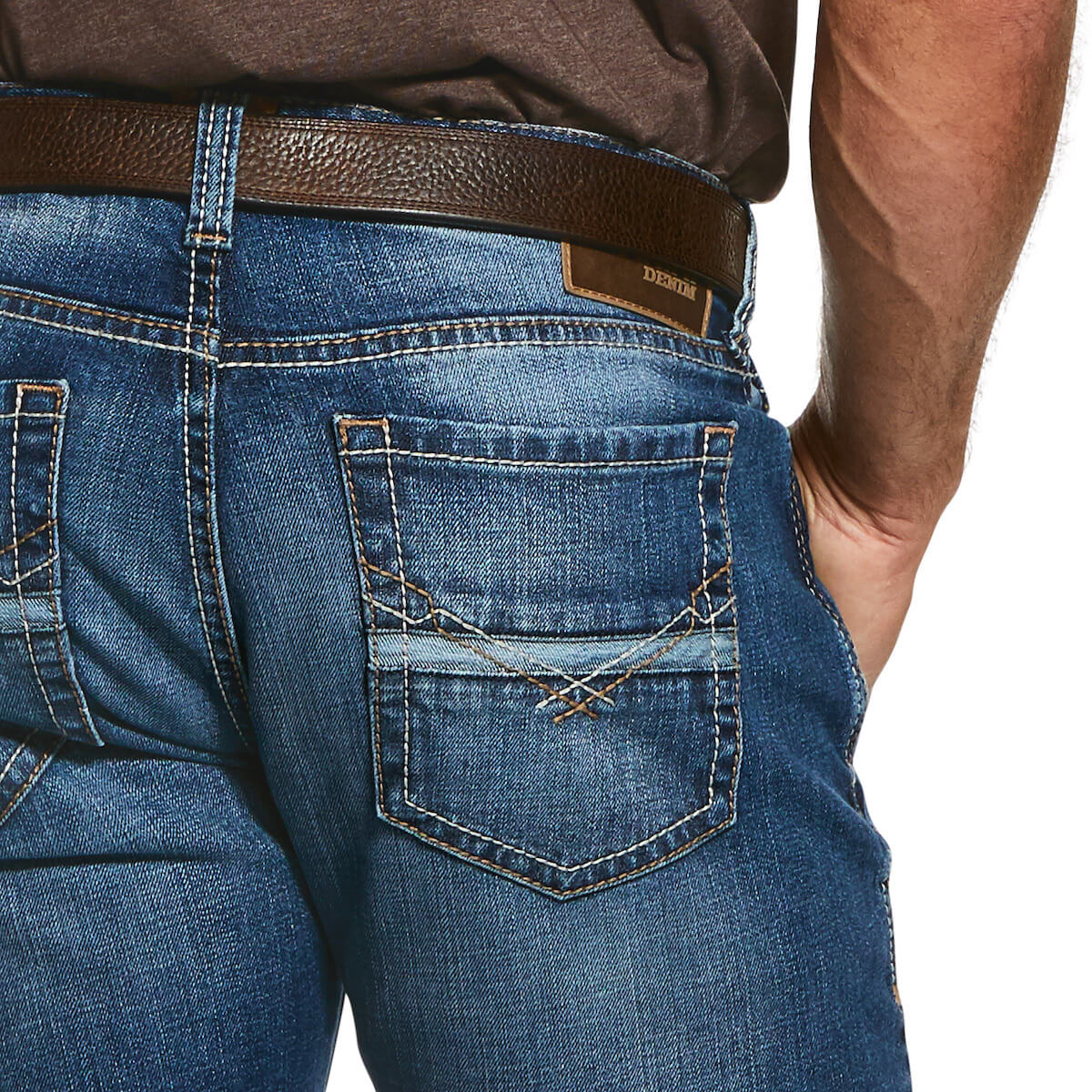 Close-up of blue jeans with a brown belt and visible brand logo.