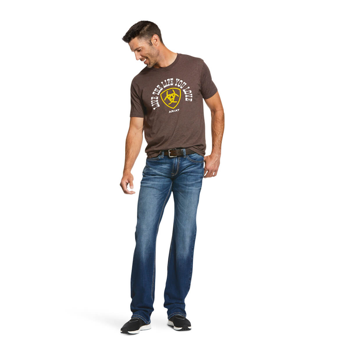 Man wearing a brown t-shirt with graphic design and blue jeans on a white background