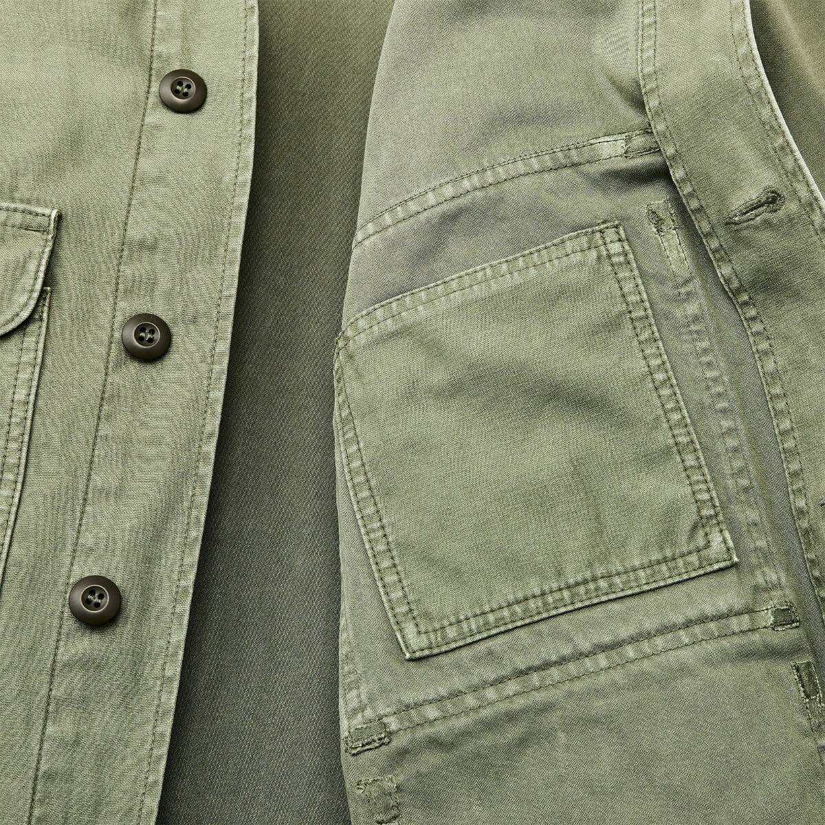 Close-up of a green jacket with button details and a pocket.