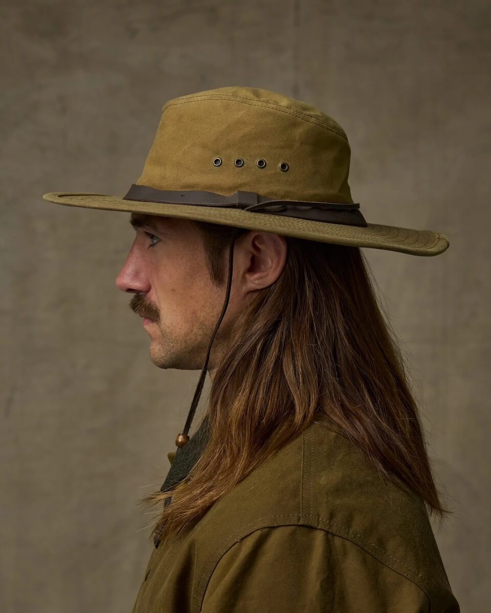 Man wearing a tan Filson hat with a wide brim against a neutral background