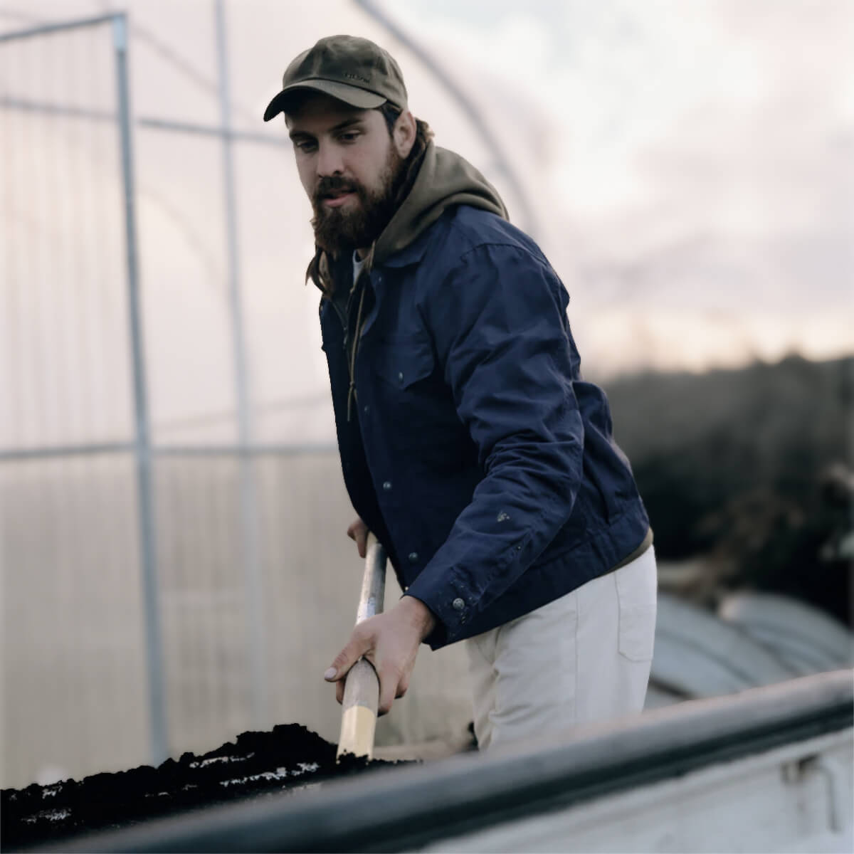 Man working with soil in a greenhouse