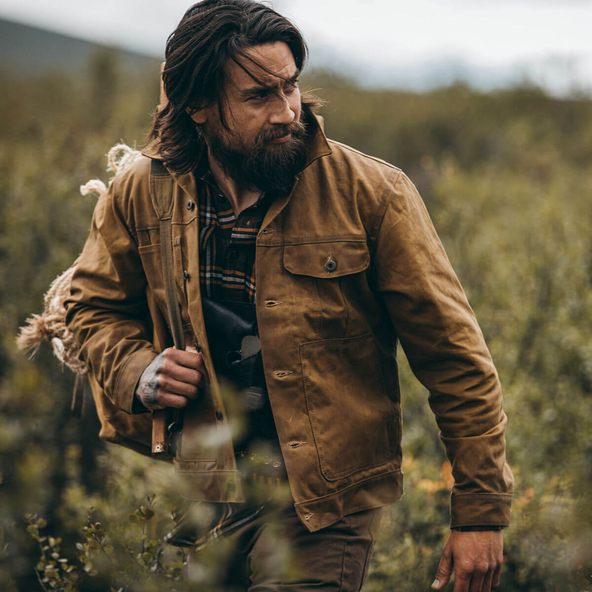 Man wearing a brown jacket in a forest setting