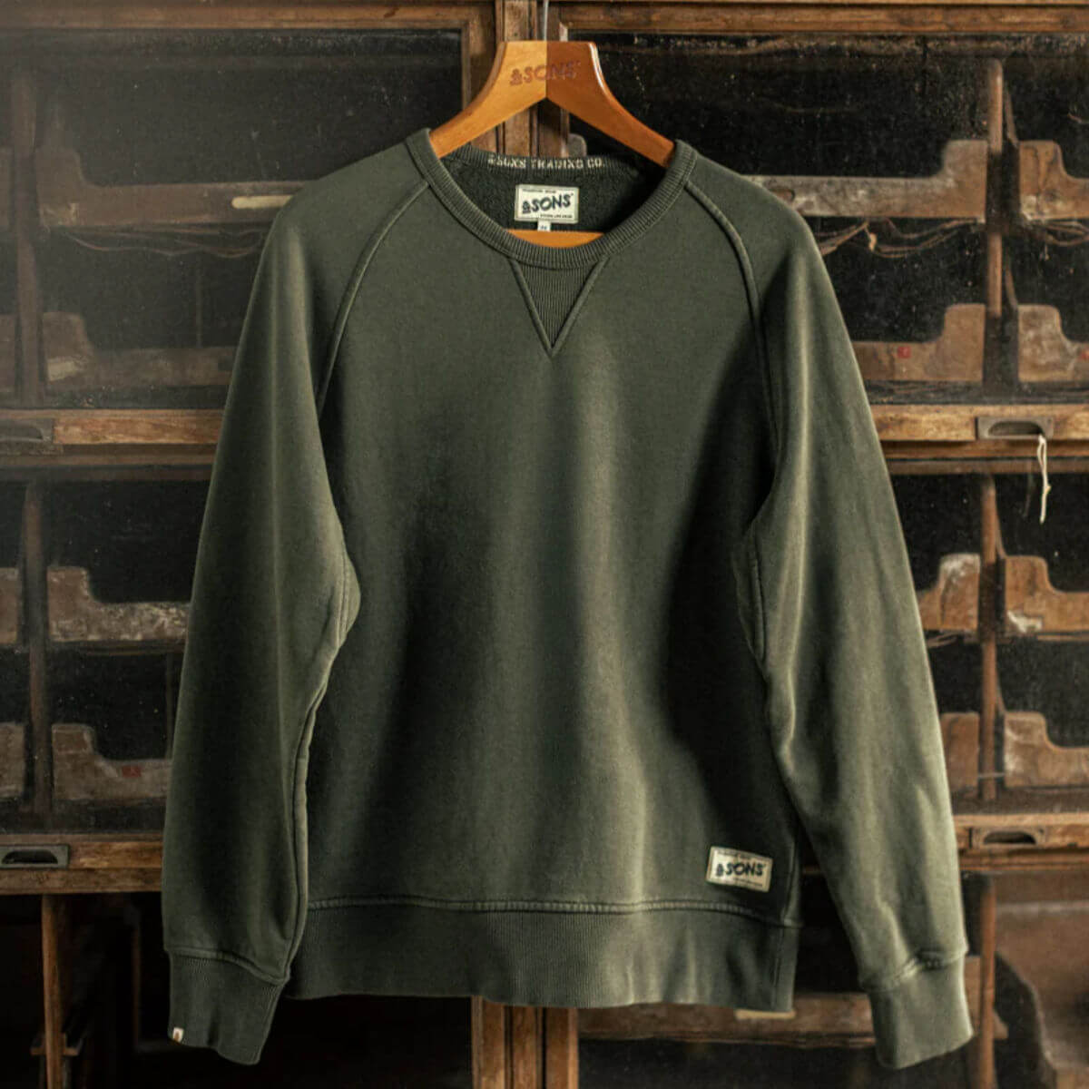 Green sweatshirt on a hanger against a vintage typewriter background