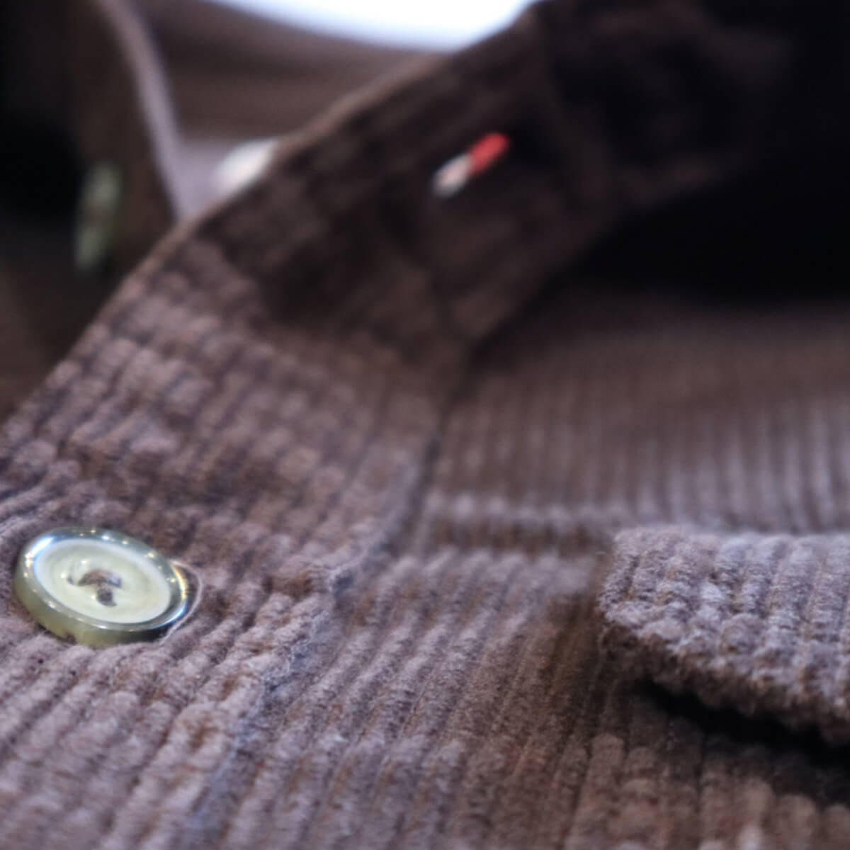 Close-up of a brown textured fabric with a button
