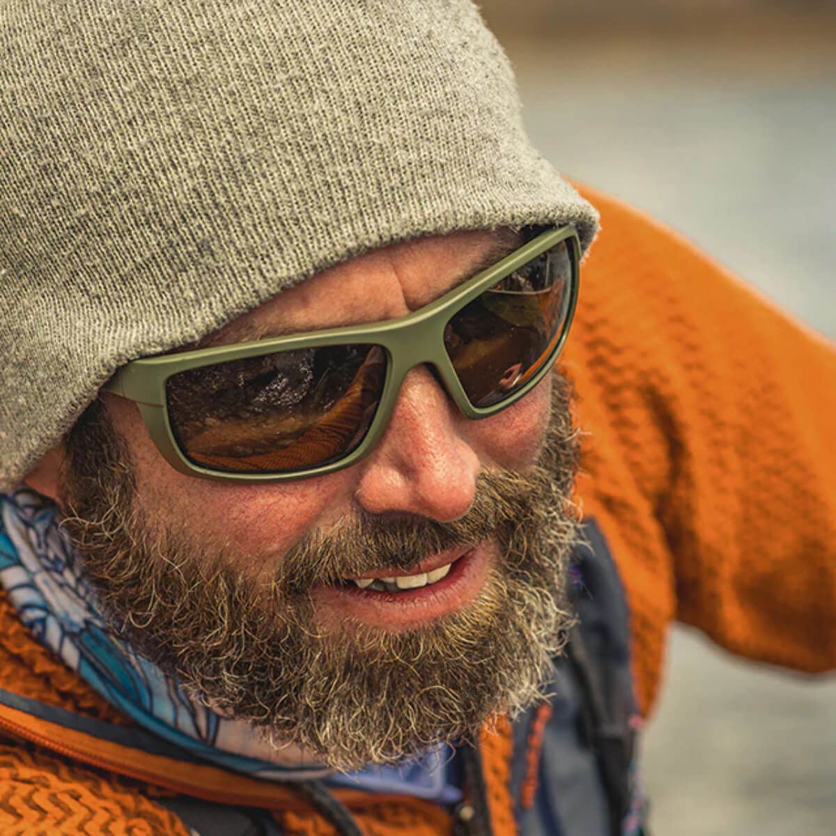 Man wearing sunglasses and a beanie with a blurred background