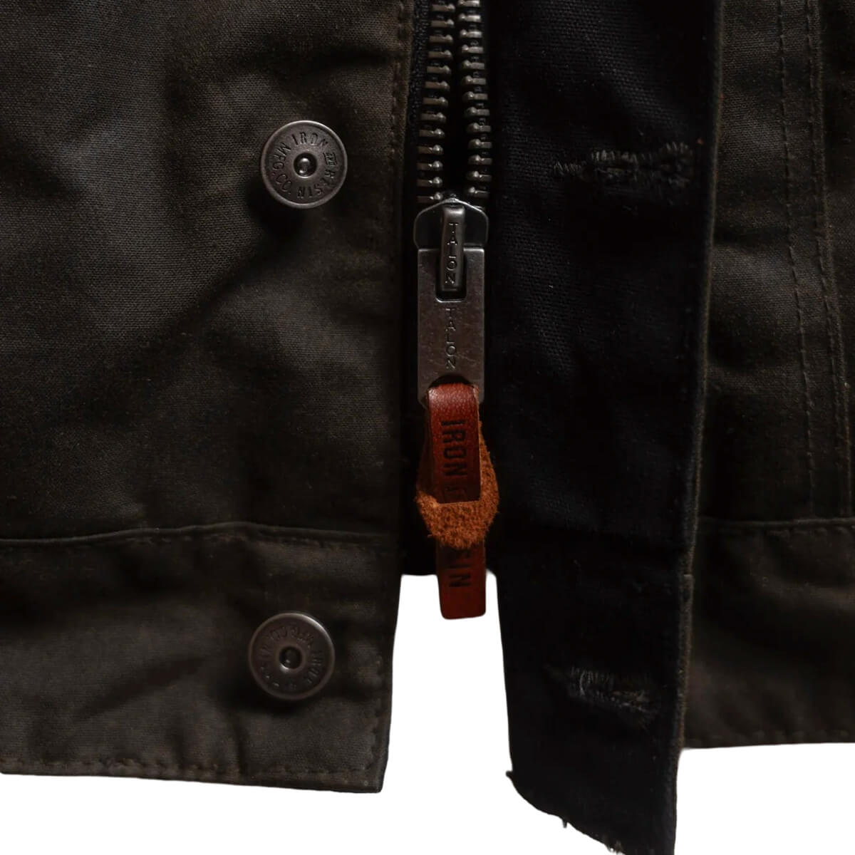 Close-up of a black jacket with buttons and a zipper on a white background