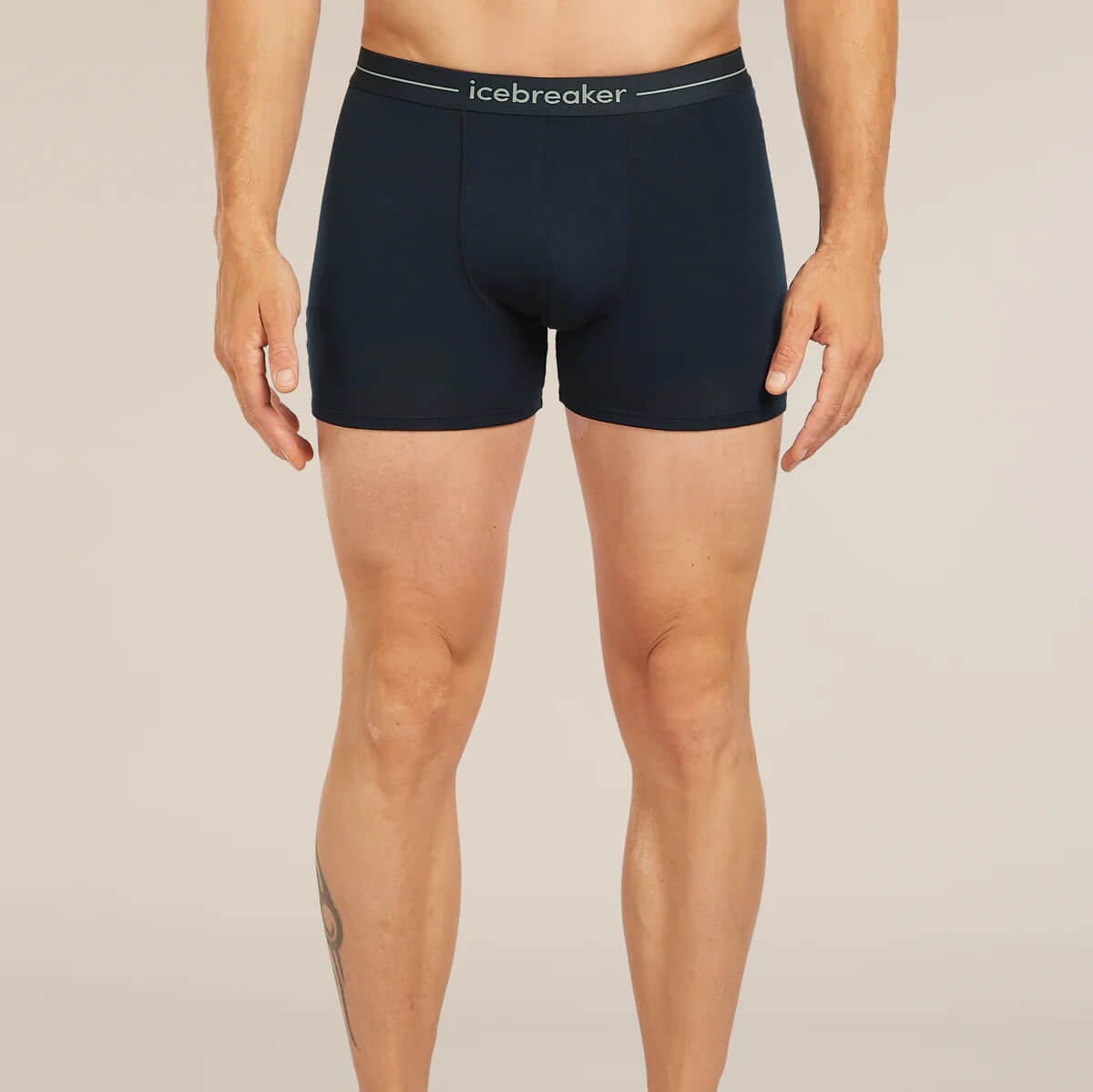 Person wearing black boxer briefs with 'icebreaker' branding on a beige background