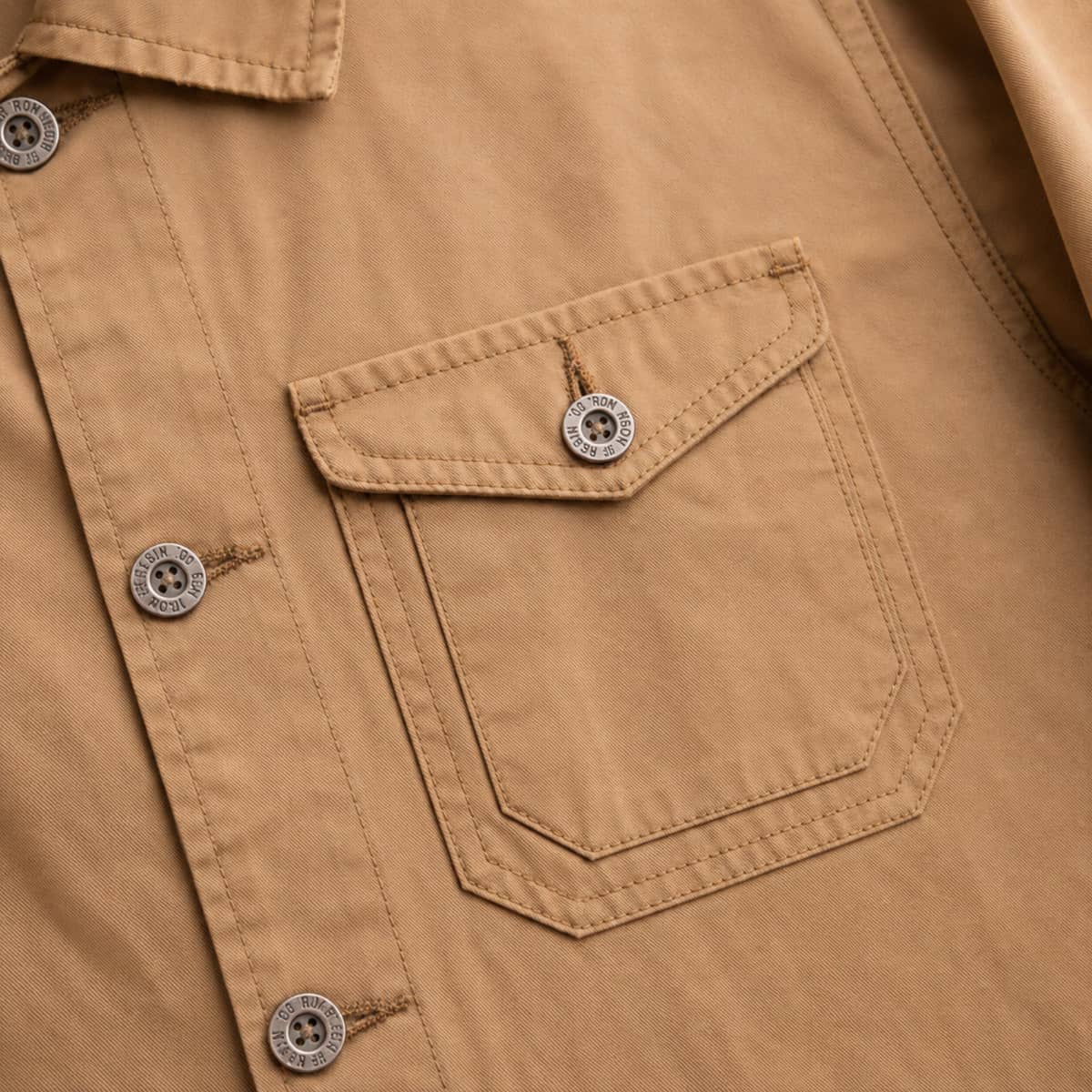 Close-up of a brown shirt with a pocket and buttons.