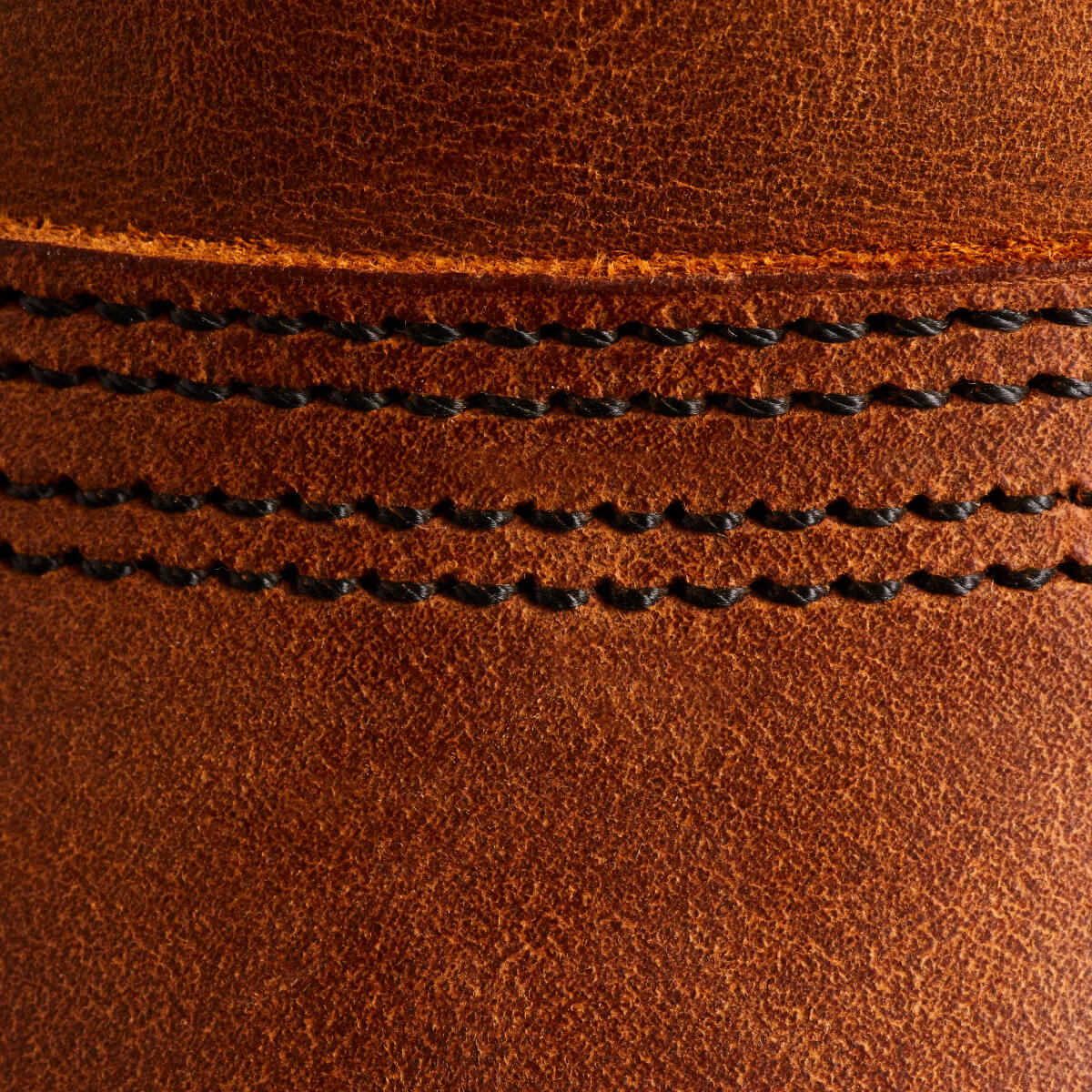 Close-up of brown leather with black stitching