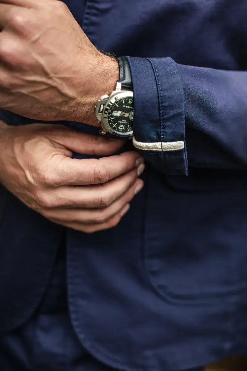 Close-up of a person wearing a watch with a blue shirt