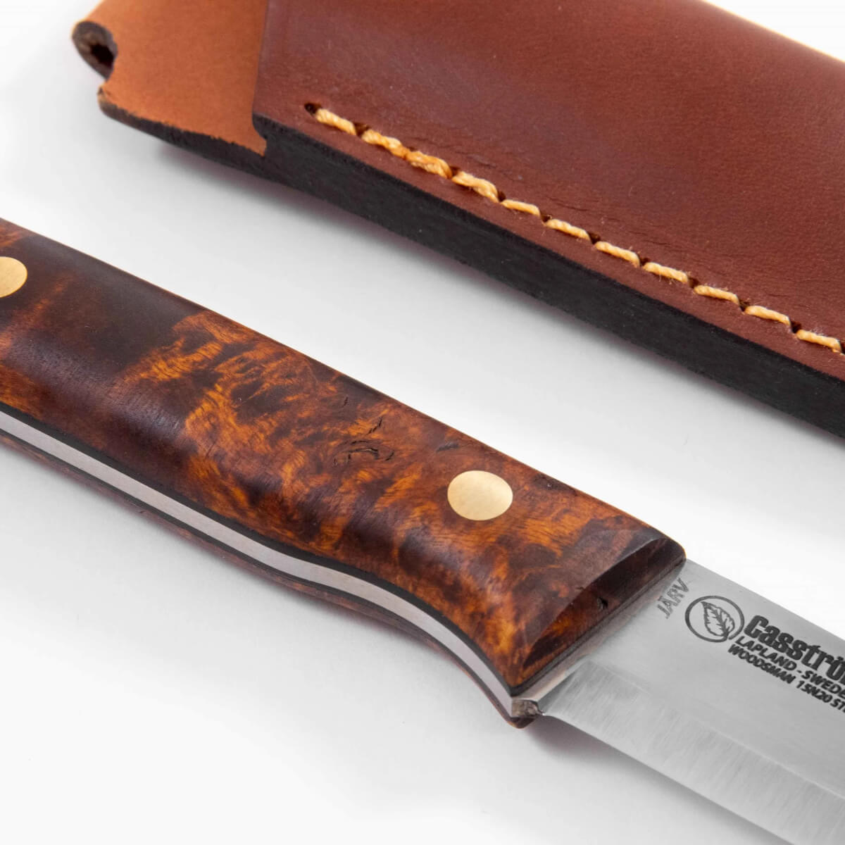 Knife with brown handle and leather sheath on a white background