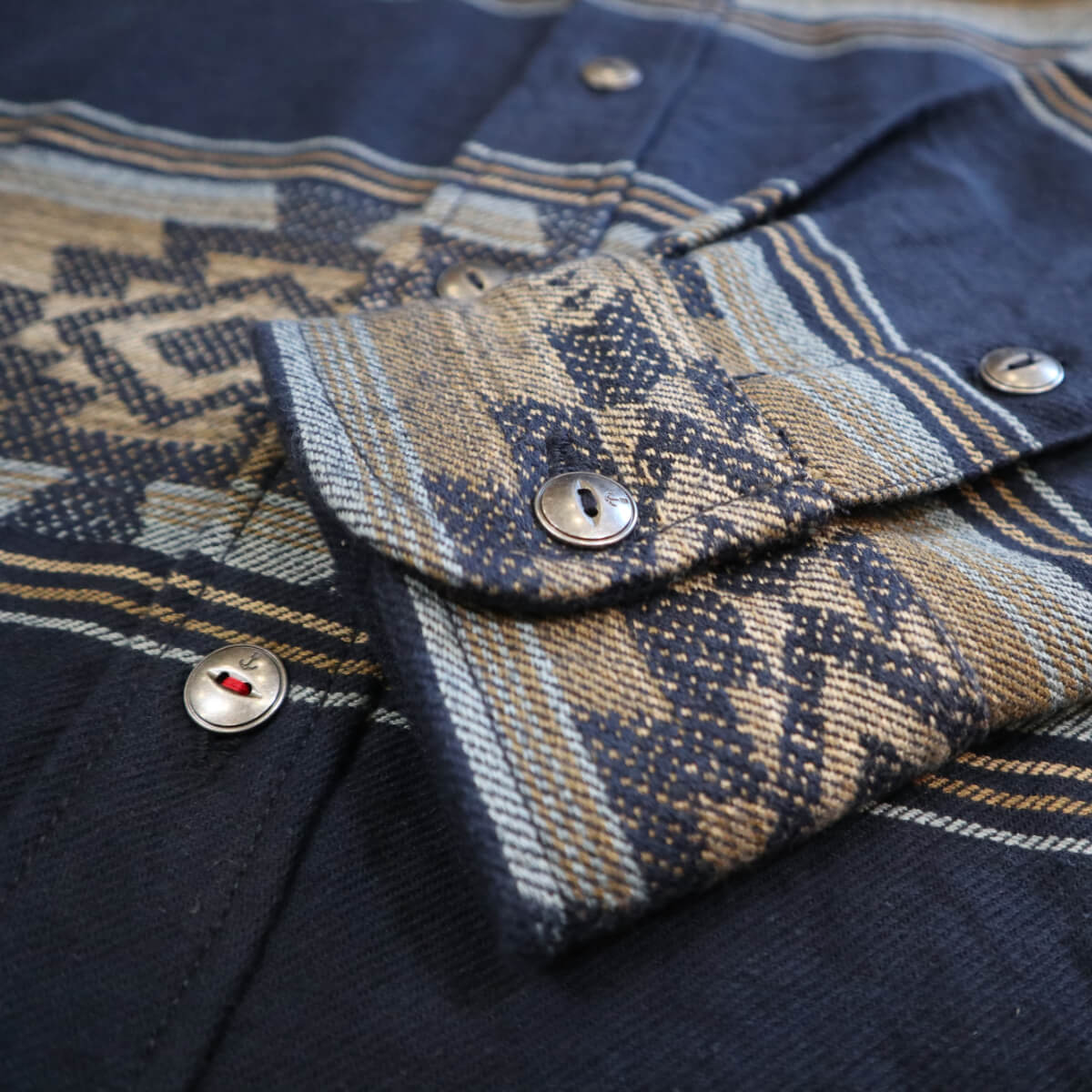 Close-up of a patterned fabric with buttons on a dark background