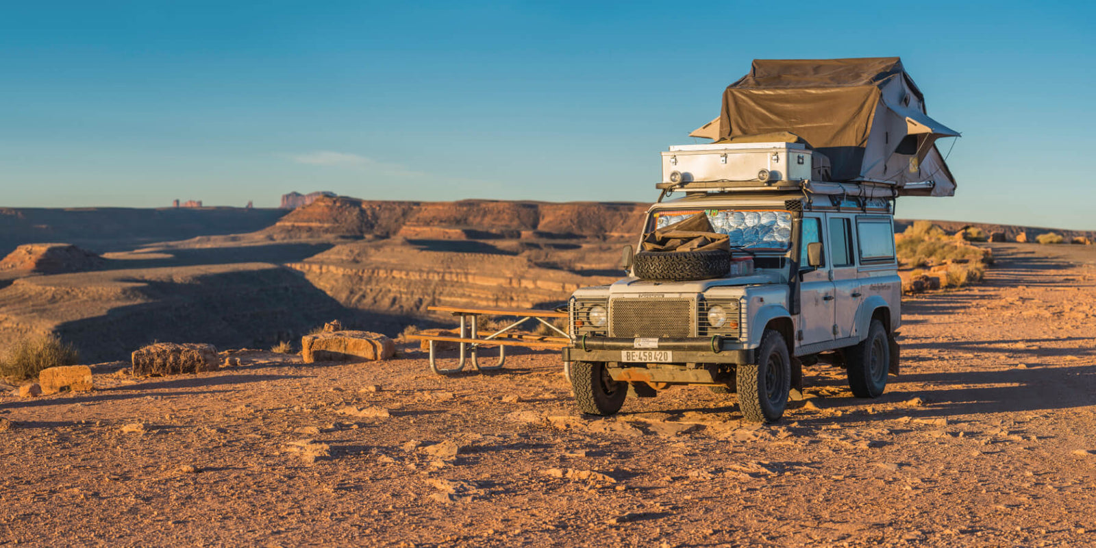 Vintage truck with a camper shell in a desert landscape
