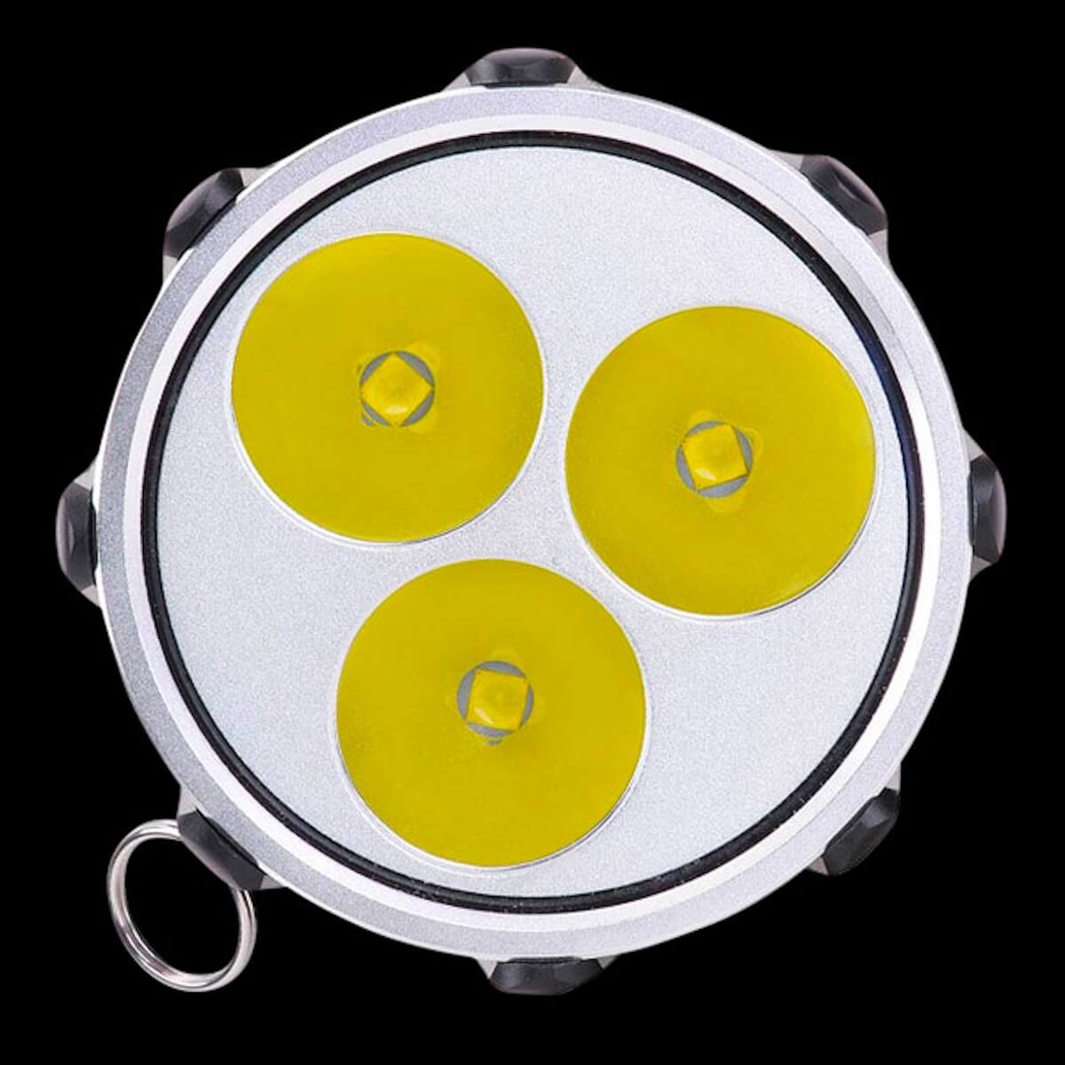 Close-up of a round light fixture with three yellow circular lenses on a black background