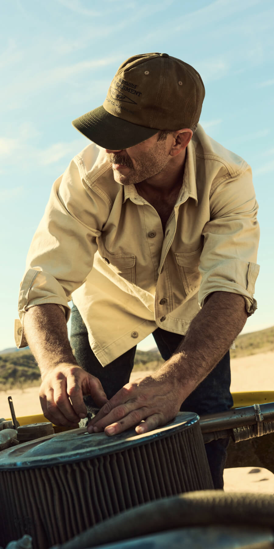 Man working on a car in an outdoor setting