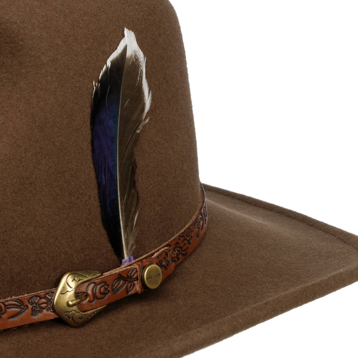 Brown cowboy hat with a feather and decorative band on a white background