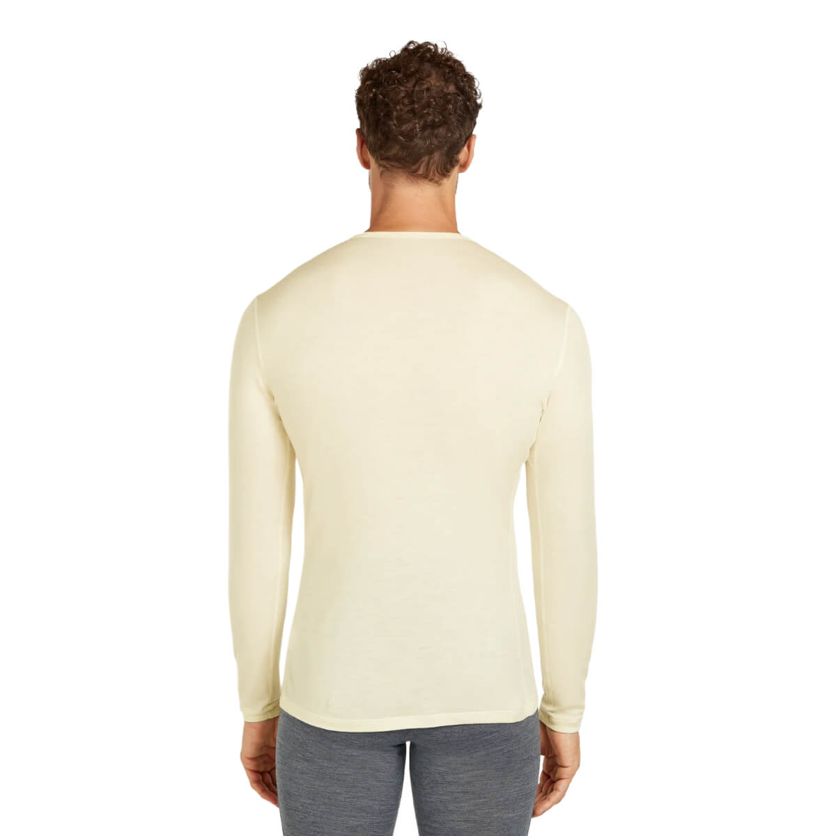 Man wearing a light yellow long-sleeve shirt on a white background