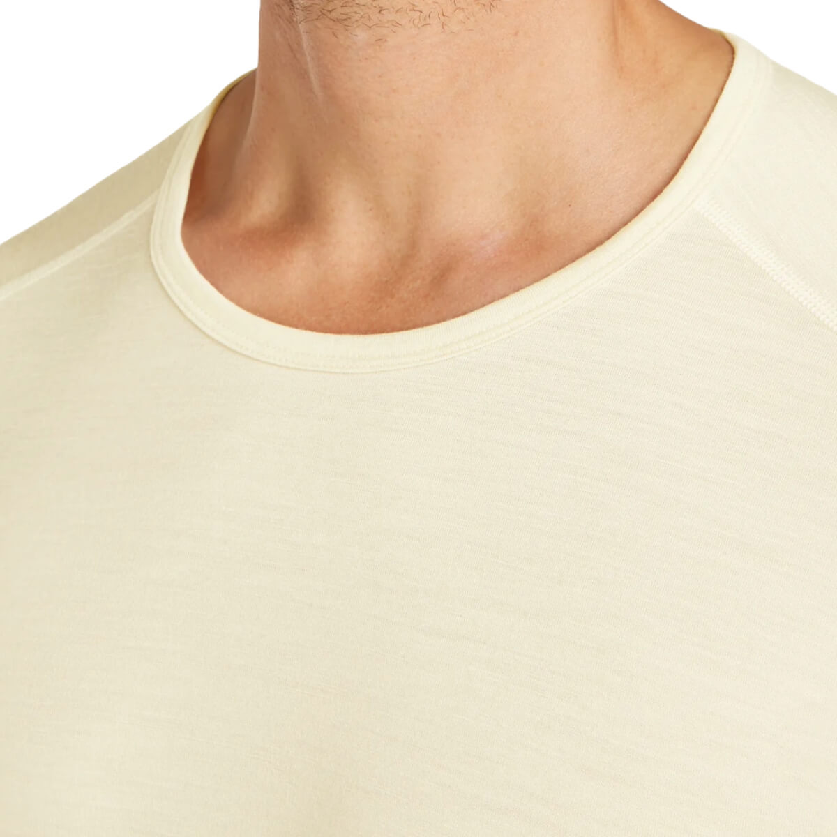 Close-up of a person wearing a light-colored shirt with a plain background