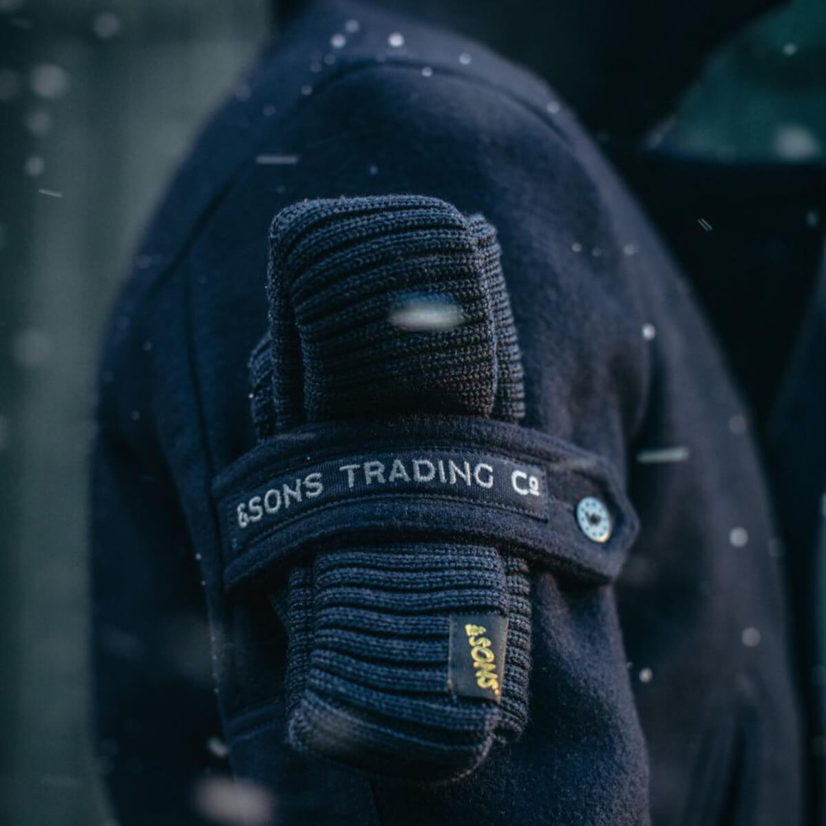 Close-up of a dark blue glove with visible branding on a blurred background