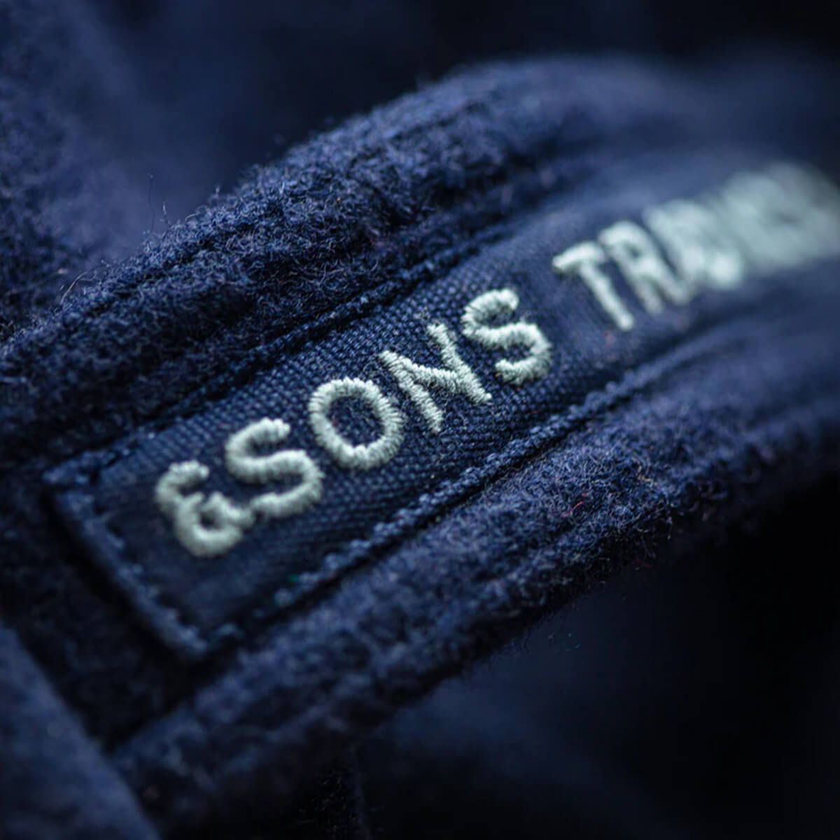 Close-up of a textured fabric with embroidered text on a dark background