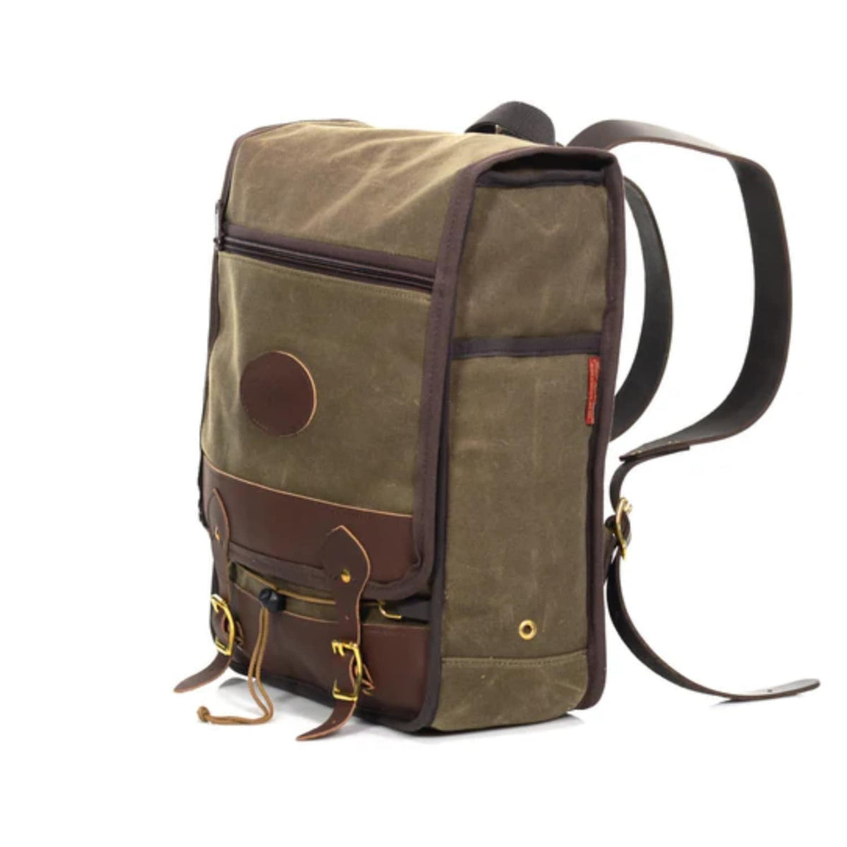 A canvas and leather Frost River backpack in olive green and dark brown, featuring a circular patch on the front pocket, brass hardware, and adjustable shoulder straps, photographed on a white background.