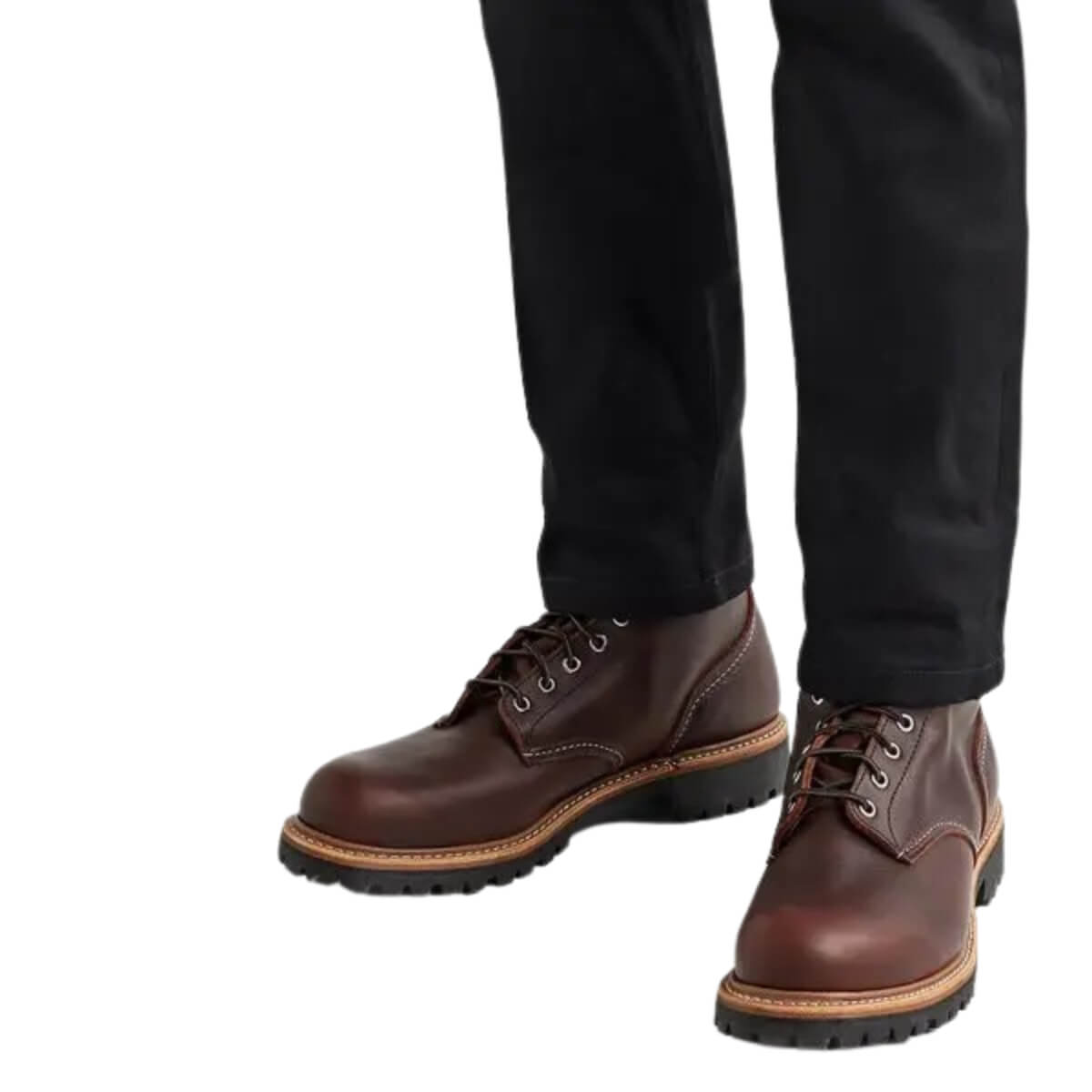 Brown leather shoes worn with black pants on a white background
