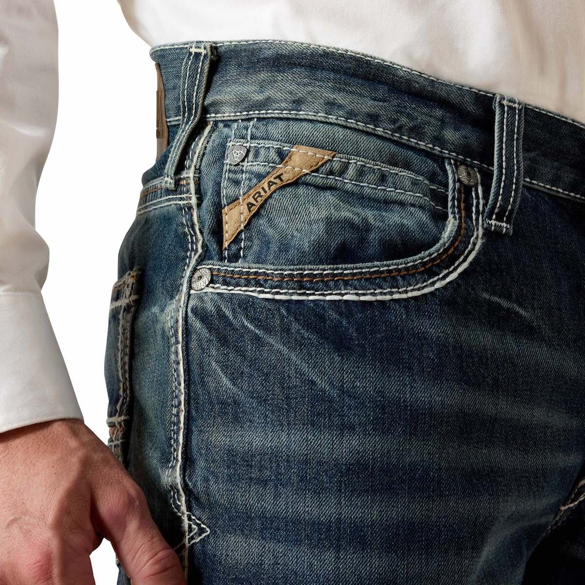 Close-up of blue jeans with a brand label on a white background