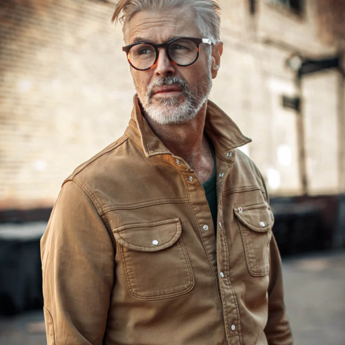 Man wearing a brown &amp;SONS shirt and glasses with a blurred background