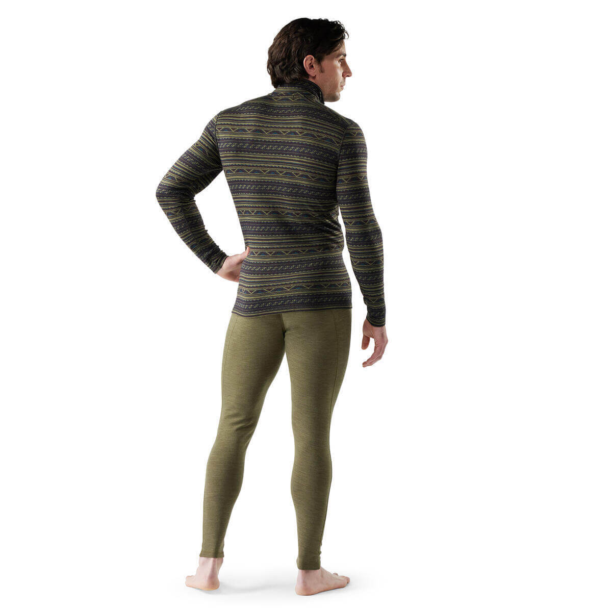 Person wearing a patterned long-sleeve shirt and green leggings on a white background