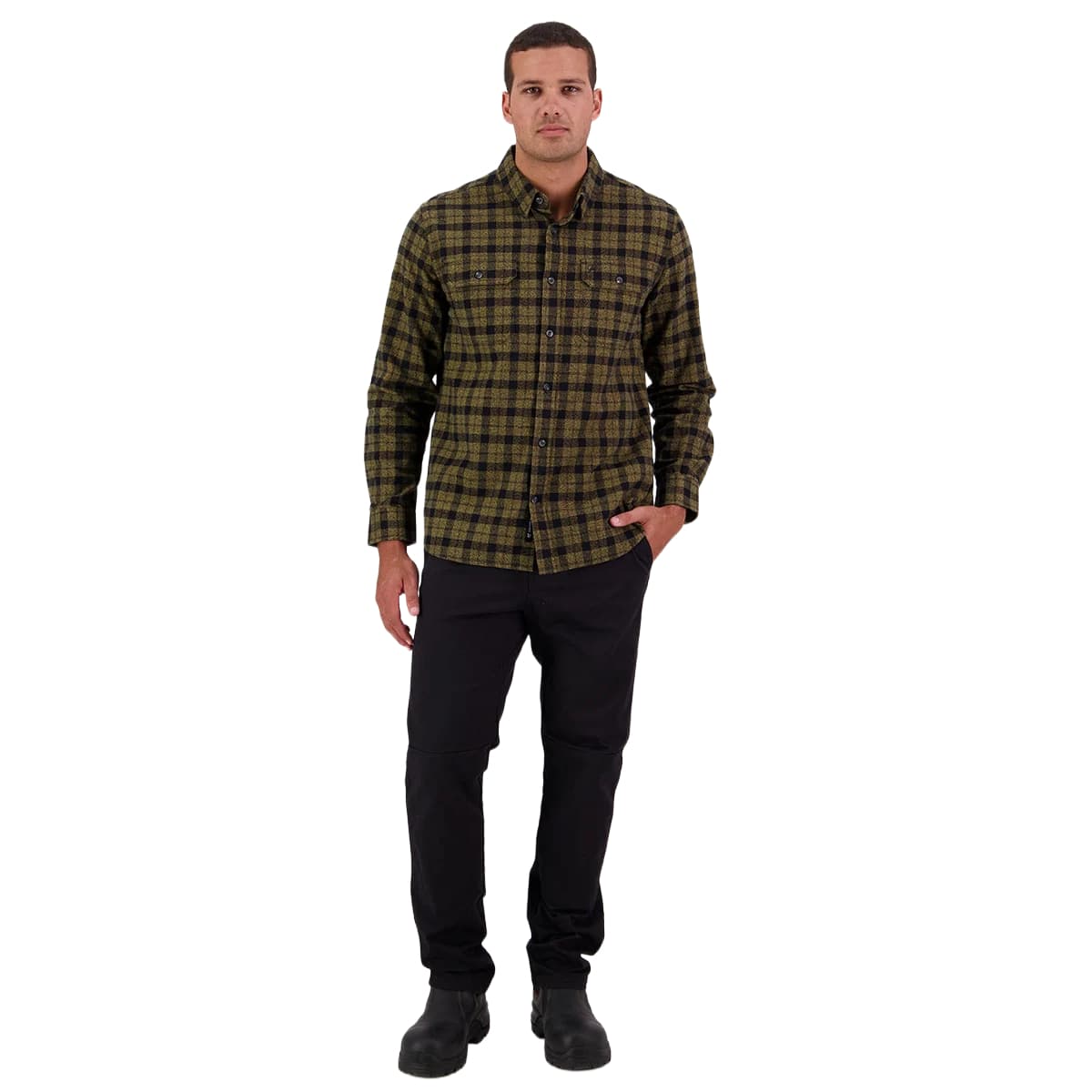 A man modeling a long-sleeve button-up plaid flannel shirt in olive green and black, paired with black pants and black boots, against a solid white background.