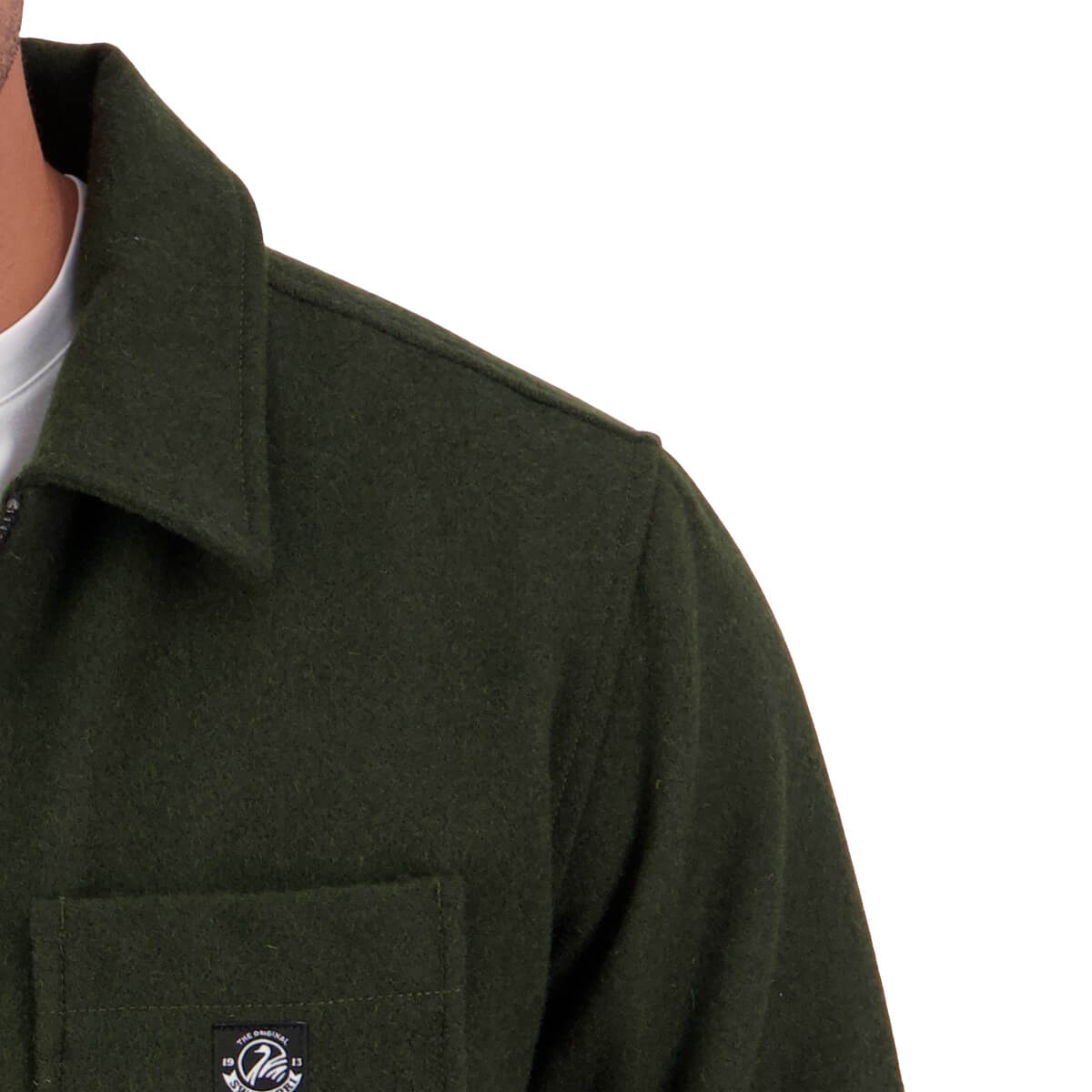 Close-up of a green coat with a brand logo on a white background