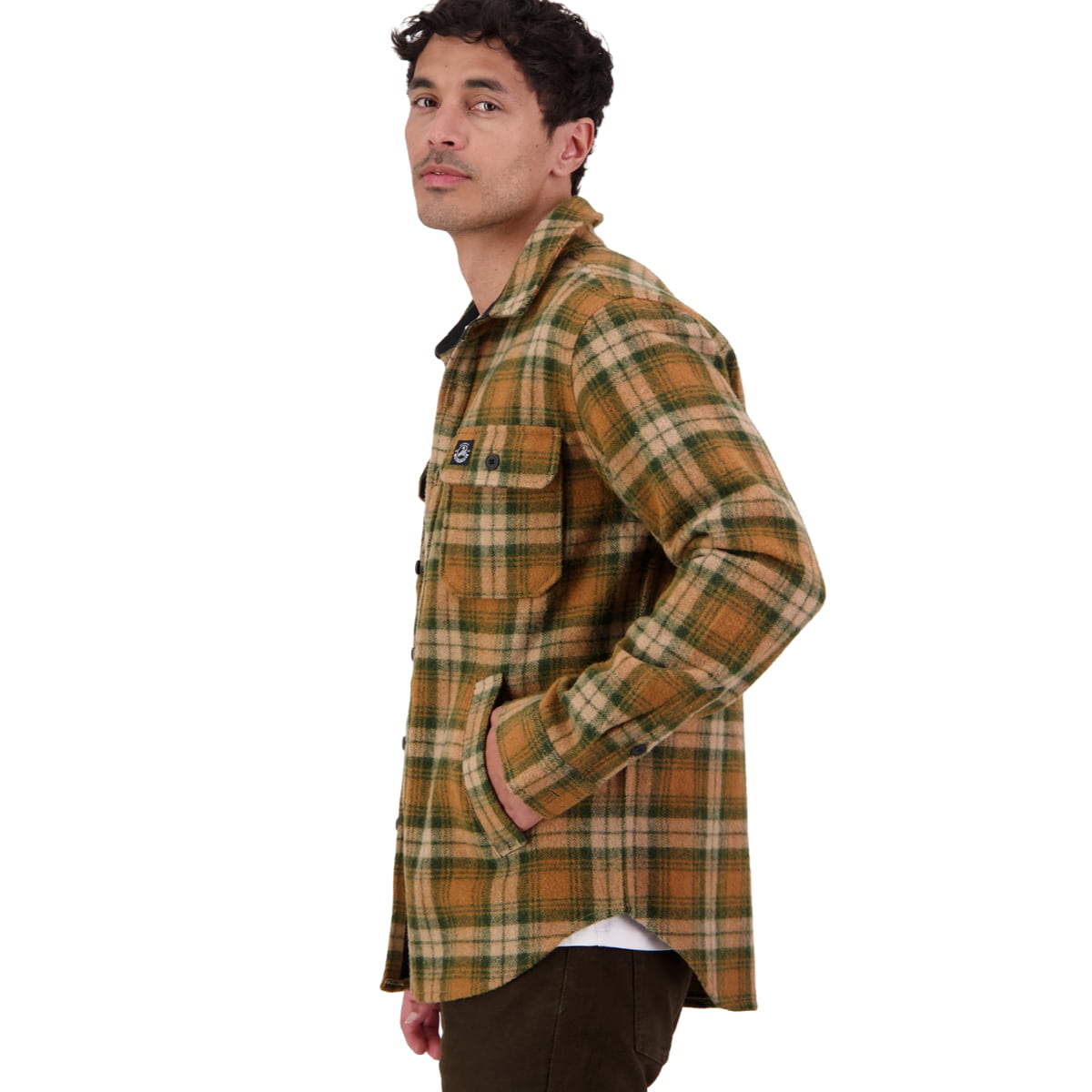 A man wearing a brown and green plaid flannel shirt jacket, shown in profile against a plain white background.
