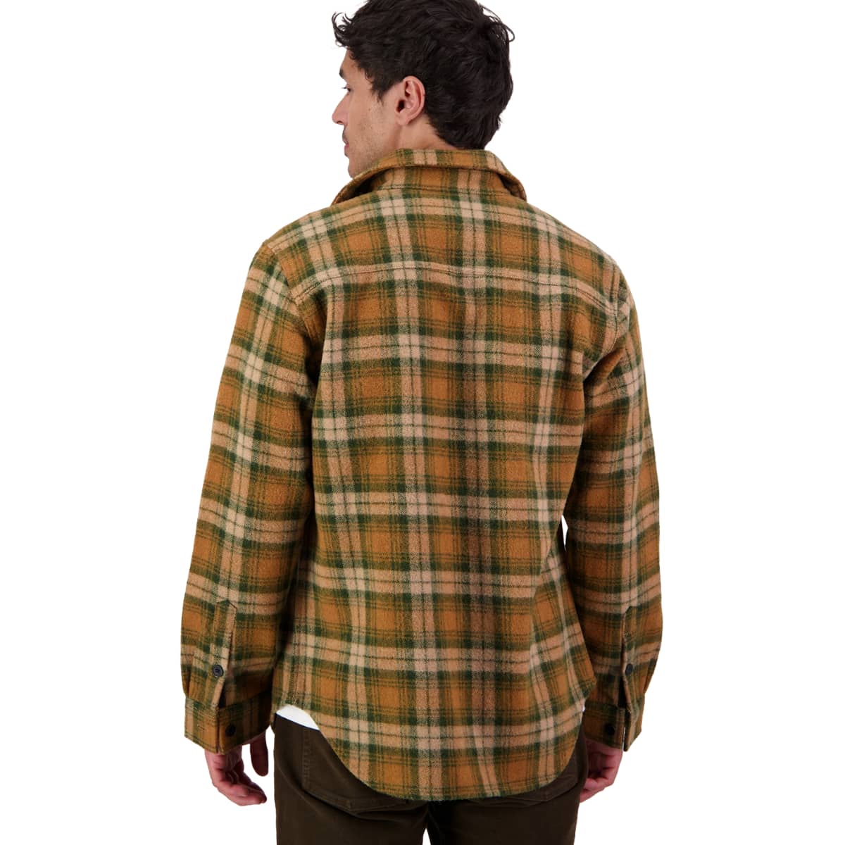 A man viewed from the back wearing a long-sleeve plaid flannel shirt in brown, green, and beige, paired with dark brown pants, against a plain white background.