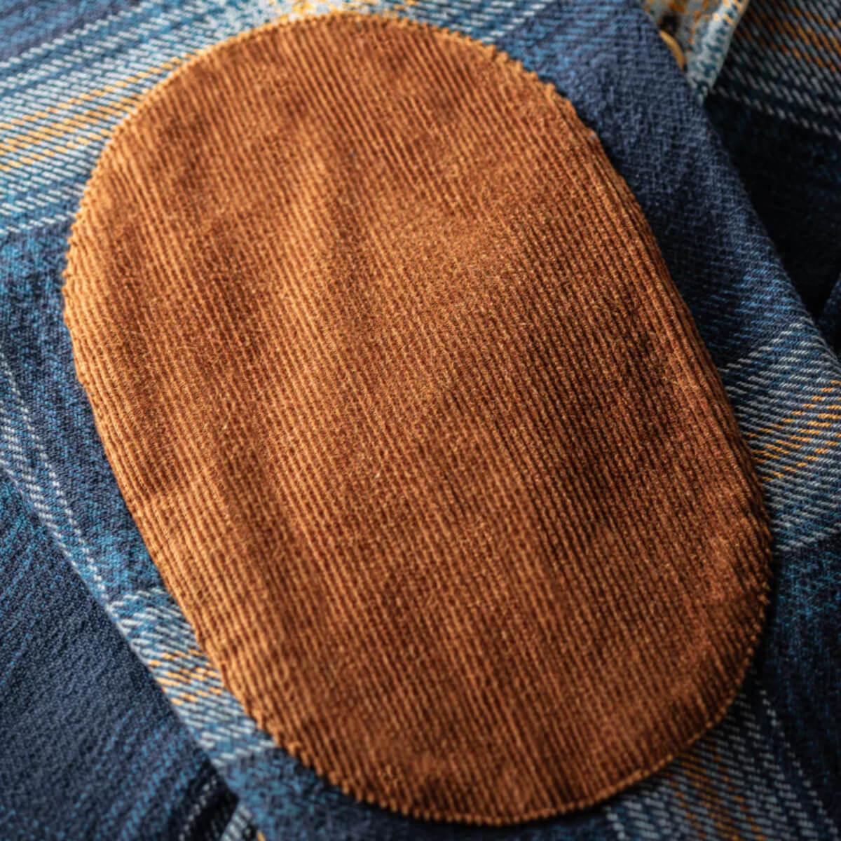 Brown leather patch on blue denim fabric