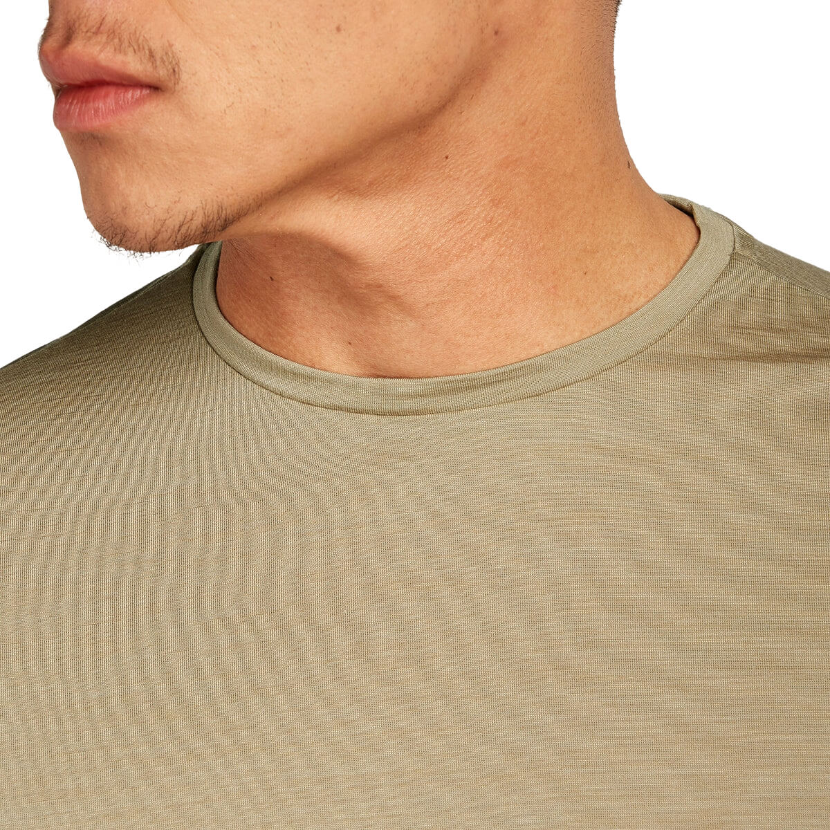 Close-up of a person wearing a beige t-shirt with a neutral background